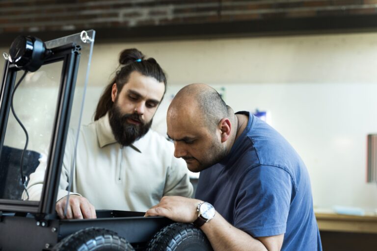 Two people checking out a robot.