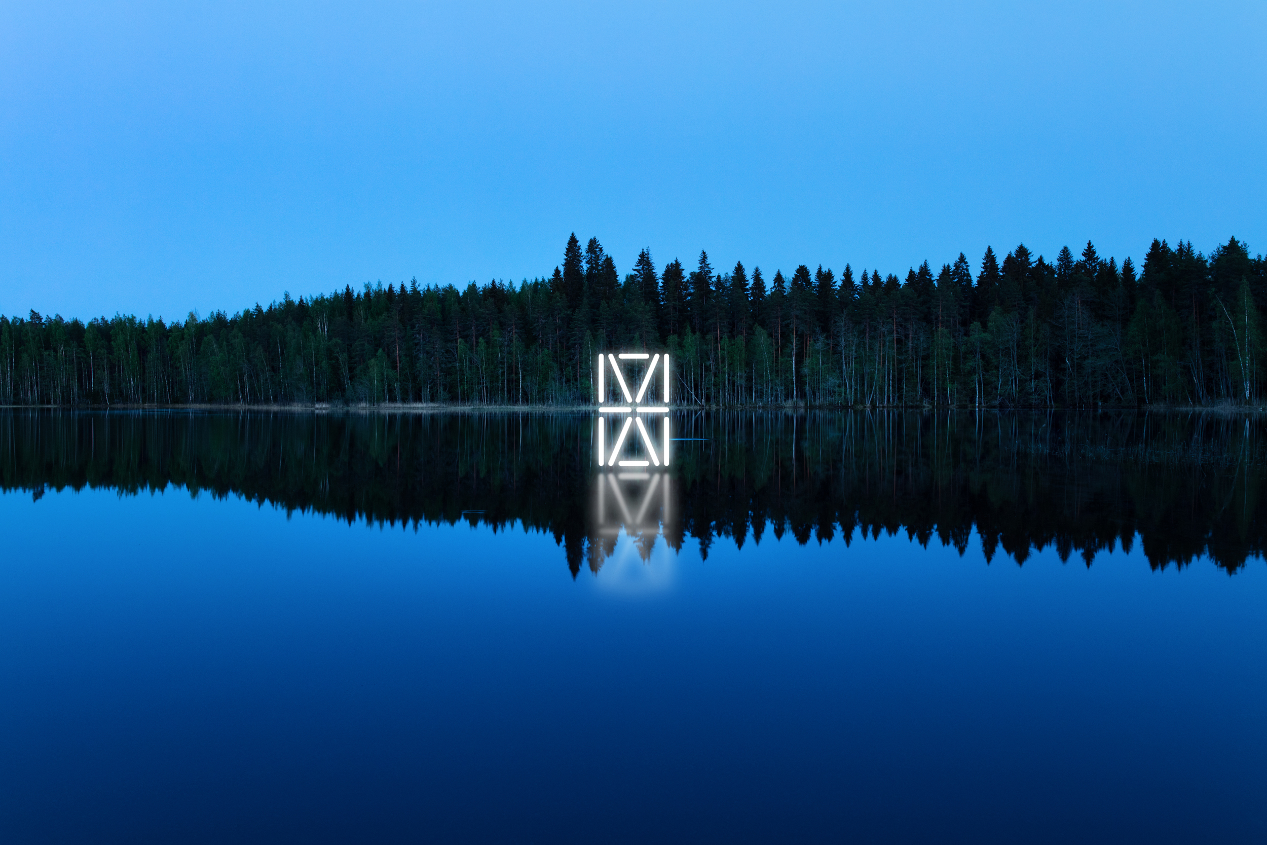 HAMK logo veden päällä takana metsää/HAMK logo above water, behind forest