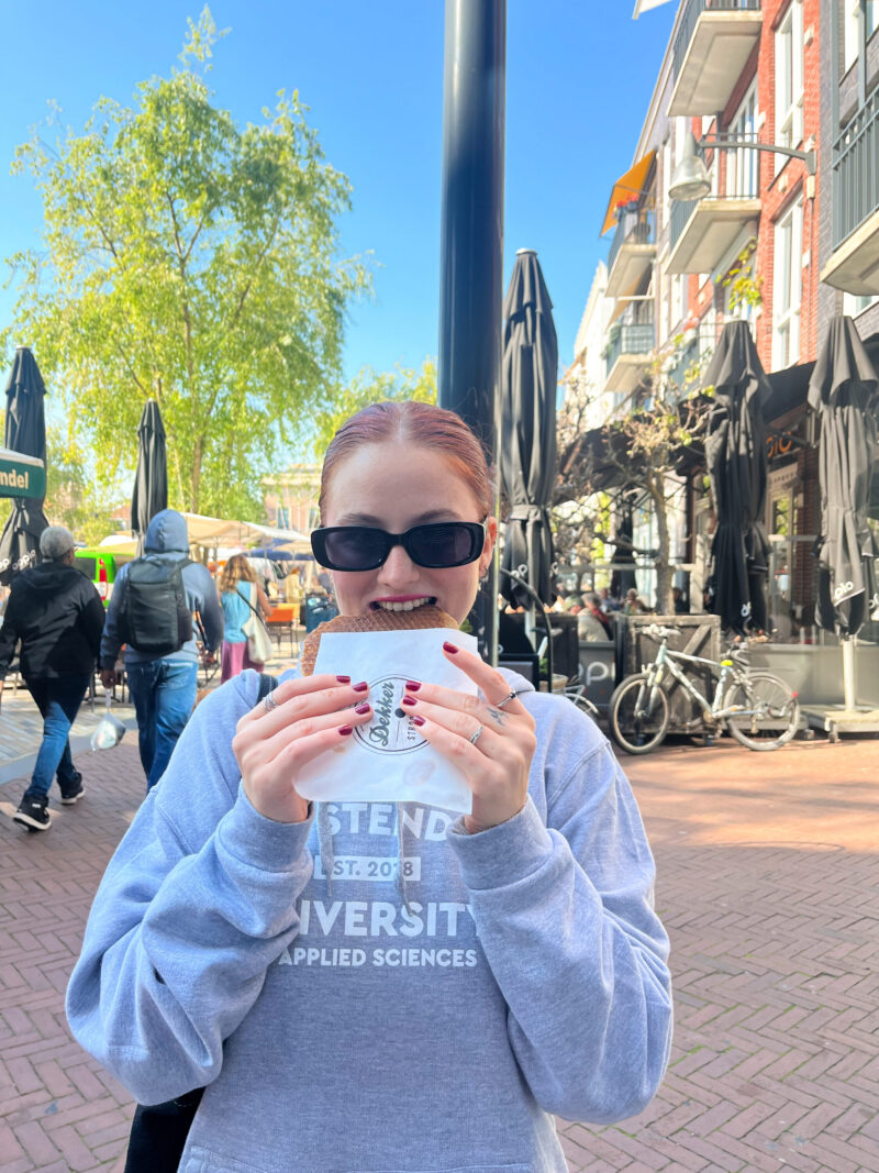 Martyna eating a stroopwaffel in the street in Leeuwarden.