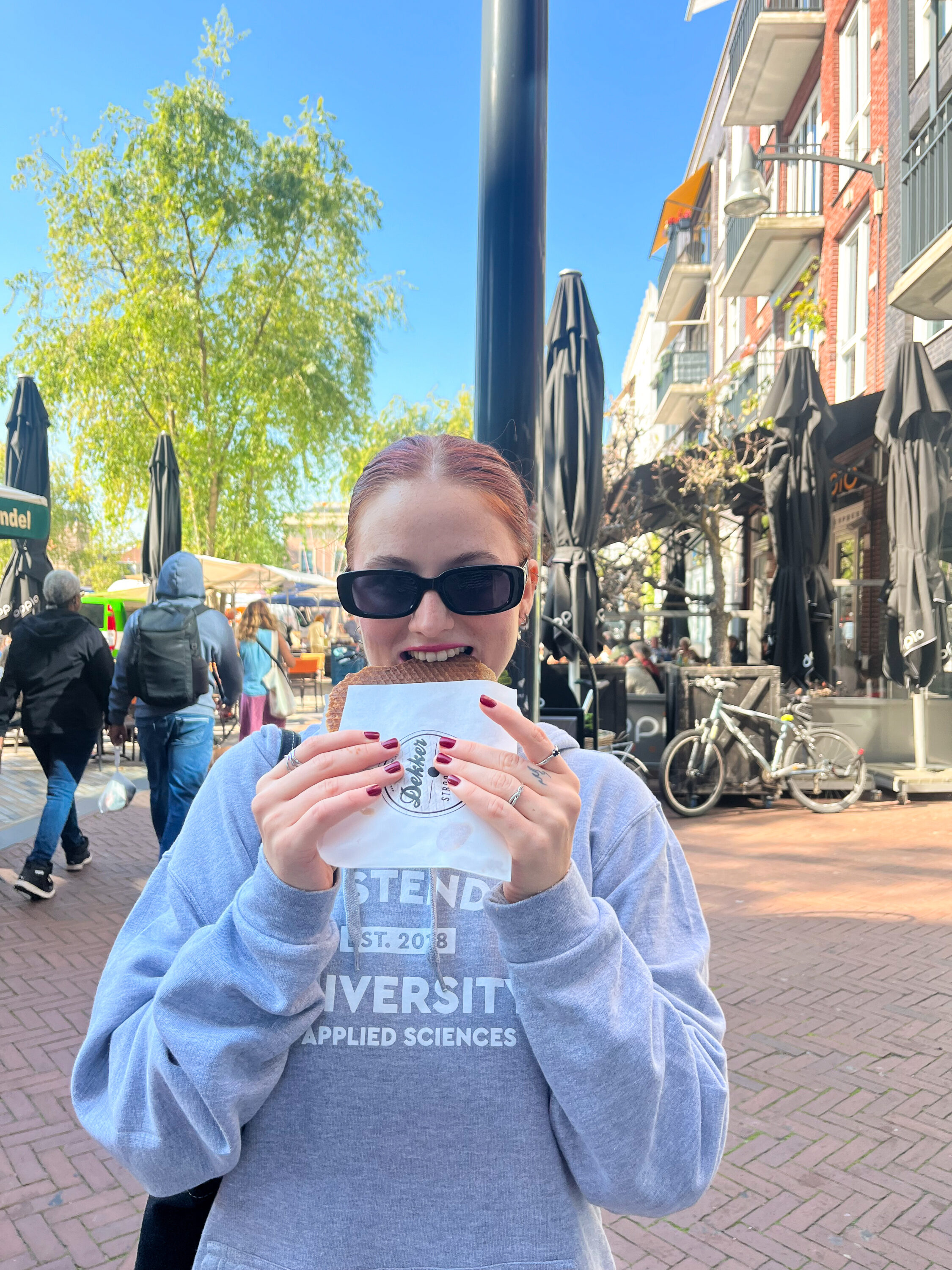 Martyna eating a stroopwaffel in street in Leeuwarden.