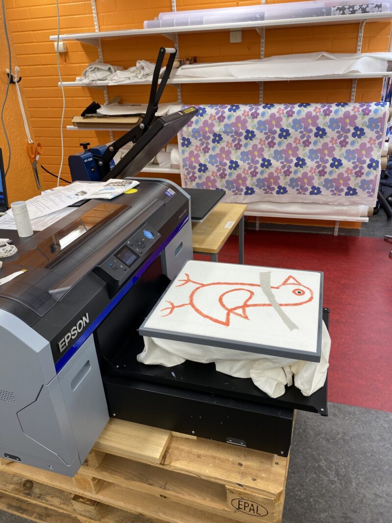 Printer printing out a sketch on a t-shirt